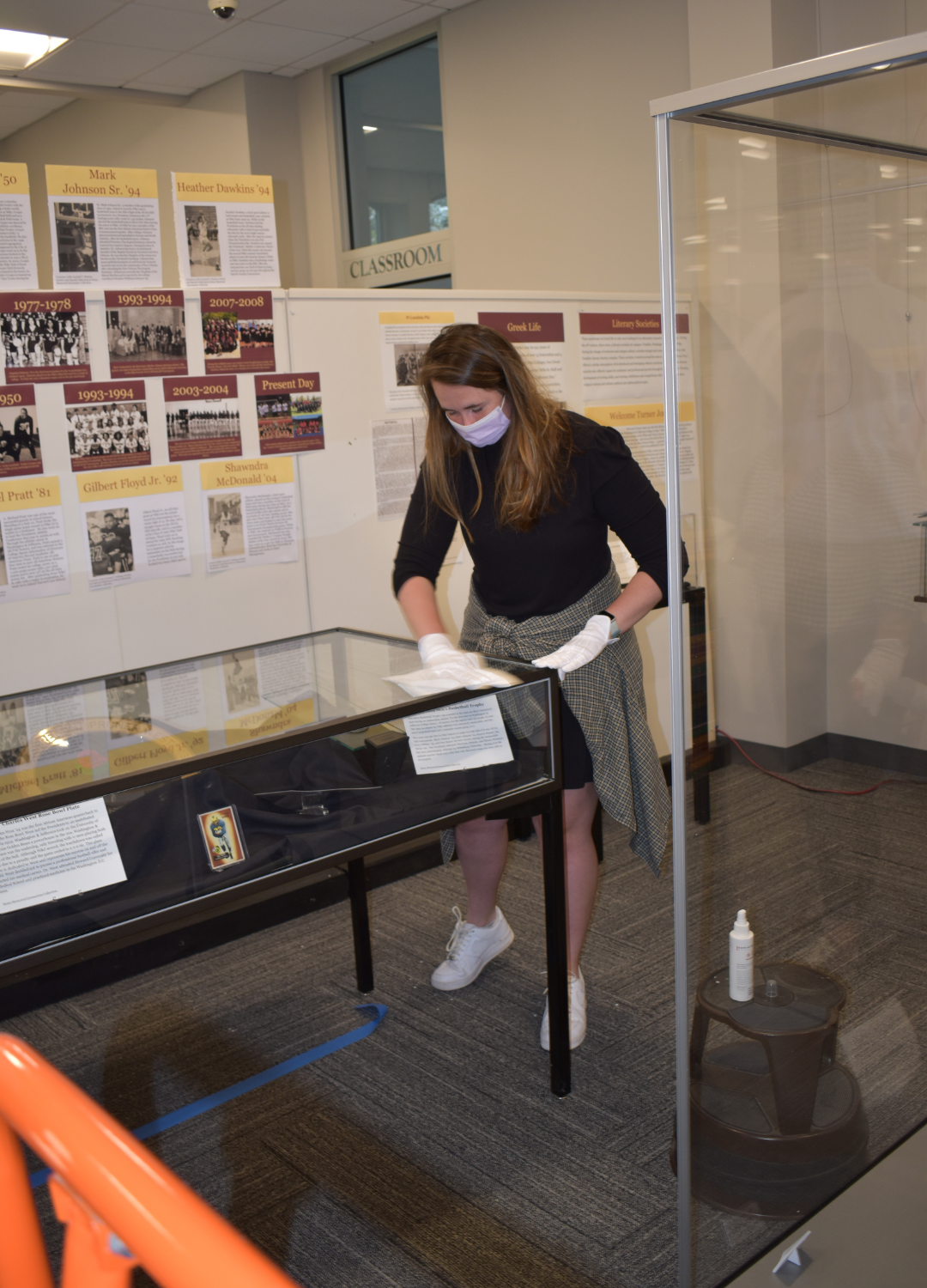 A student from Dr. Kieran's class cleaning a display case