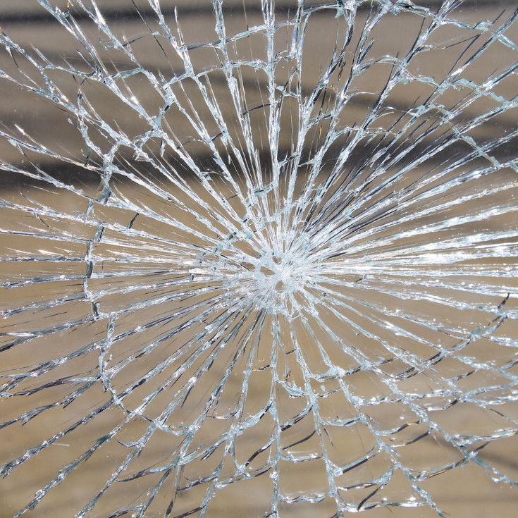 Broken laminated glass in classic spiderweb pattern